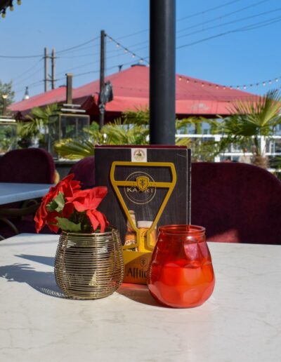 Terras van Italiaans Restaurant San Mario's met uitzicht op de kade en Aanloophaven van Zeewolde, met gedekte tafels, rode accenten en een sfeervolle buitenzitplaats.